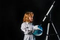 A little boy with telescope and space helmet dreams of becoming an astronaut and flying into space. Cosmos childrens in Royalty Free Stock Photo