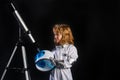 A little boy with telescope and space helmet dreams of becoming an astronaut and flying into space. Cosmos childrens in Royalty Free Stock Photo