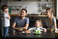 Little boy telling story, poems standing on chair at breakfast