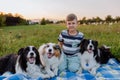 Little boy with three collies outdoor, having picnic.