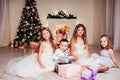 The little boy and three girls kids open Christmas presents new year winter Christmas tree Royalty Free Stock Photo