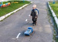 A little boy of three years old is playing around the kindergarten with his toy truck Royalty Free Stock Photo