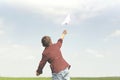 A little boy throwing a paper plane in the sky Royalty Free Stock Photo