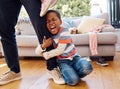 Hes having a bad day. a little boy throwing a tantrum while holding his parents leg at home. Royalty Free Stock Photo