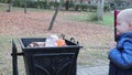 A little boy throws garbage in the trash in the street. The concept of waste management and environmental protection. Proper paren