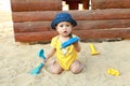 Baby boy playing in sand with scoop in sandbox Royalty Free Stock Photo