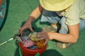 A little boy, toddler, playing fishing with plastic fish, his red bucket filled with toys Royalty Free Stock Photo