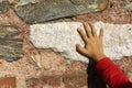 Little boy is touching stone wall with his hand Royalty Free Stock Photo