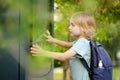 Little boy tourist studying at the big public outdoor street map of city. Kid touching screen and looking for the way. Child is Royalty Free Stock Photo