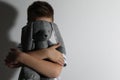 Little boy with toy near white wall. Domestic violence concept Royalty Free Stock Photo