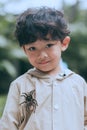 Little boy in trench coat smiling and tilting his head Royalty Free Stock Photo