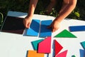 Little boy tries to solve the puzzle, moving different geometric shapes