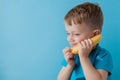 Little Boy tries to speak by means of a banana instead of phone