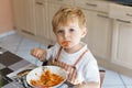 Little boy two years old eating pasta