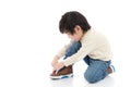 Little boy tying his shoes in white