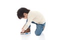 Little boy tying his shoes in white