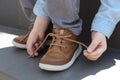 Little boy tying shoe laces on stairs outdoors, closeup