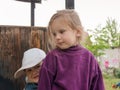 Little boy is upset and scared. The younger brother is hiding behind his sister in search of support and protection.