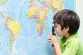 Little boy using magnify looking on map Royalty Free Stock Photo