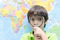 Little boy using magnify looking on map