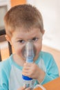 Little boy using nebulizer during inhaling therapy.