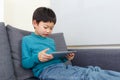 Little boy using tablet and sitting on sofa Royalty Free Stock Photo