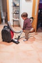 Little boy vacuuming at home doing his homework Royalty Free Stock Photo