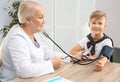 Little boy visiting doctor in hospital. Measuring blood pressure Royalty Free Stock Photo