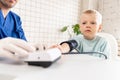 Little boy visiting doctor in hospital. Measuring blood pressure and checking pulse Royalty Free Stock Photo