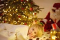 Little boy waiting Santa Claus under tree on Christmas Eve. Child is sleeping. Santa Claus brought gifts. Magic at Christmas and Royalty Free Stock Photo