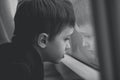 Little boy waiting by window for stop raining - black and white Royalty Free Stock Photo