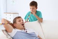 Little boy waking his father up with party blower