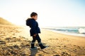 Little boy walking on beach at sunset, winter season Royalty Free Stock Photo