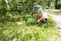 Little boy is walking with butterfly net and catching butterflies on green hills on sunny summer day Royalty Free Stock Photo