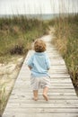 Little boy walking down beach walkway. Royalty Free Stock Photo