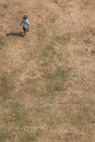 Little boy walking on a dry grass