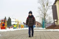 Little boy walking in the park. Child going for a walk after school with a school bag in winter. Children activity outdoors in fre Royalty Free Stock Photo
