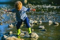 A little boy walks near the lake or river. Little boy playing near river in sunny day. Happy childhood and children Royalty Free Stock Photo