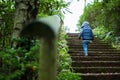 Little boy walks up steps outside in nature surrounded by greenery Royalty Free Stock Photo