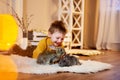 a little boy on a warm room smiling at two cute rabbits. Royalty Free Stock Photo