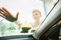 Little Boy washing his family windshield car window with soap foamy sponge. Inside car camera view