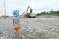 Little boy watching truck loaded with sand by excavator Royalty Free Stock Photo