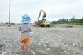 Little boy watching truck loaded with sand by excavator Royalty Free Stock Photo