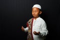 A little boy wearing a cap is praying isolated on black background Royalty Free Stock Photo