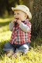 Little boy wearing a cowboy hat playing on nature Royalty Free Stock Photo