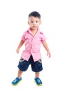 Little boy wearing pink shirt standing over white