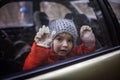 Little boy wearing respirator mask and medical gloves looking through a car window, stay safe Royalty Free Stock Photo