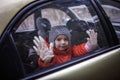 Little boy wearing respirator mask and medical gloves looking through a car window, stay safe Royalty Free Stock Photo