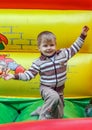 A little boy wearing striped sweater jumps on a trampoline. Royalty Free Stock Photo