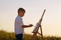 Boy drawing on canvas in open air Royalty Free Stock Photo